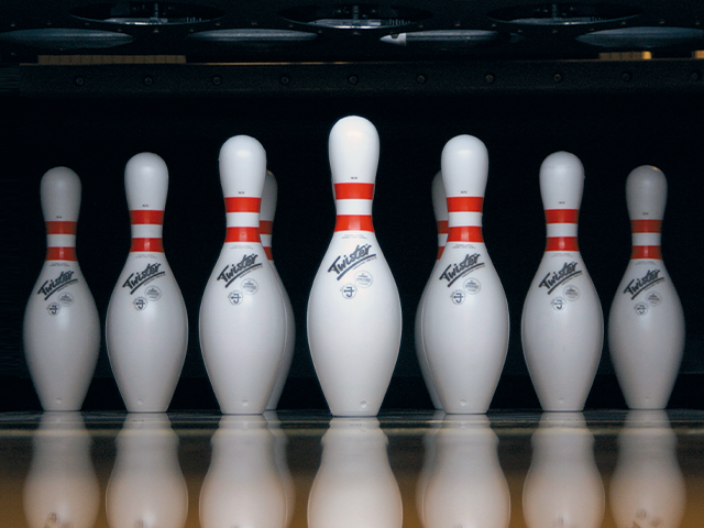 Echte Twister-Bowlingpins mit roten Streifen auf einer Bowlingbahn